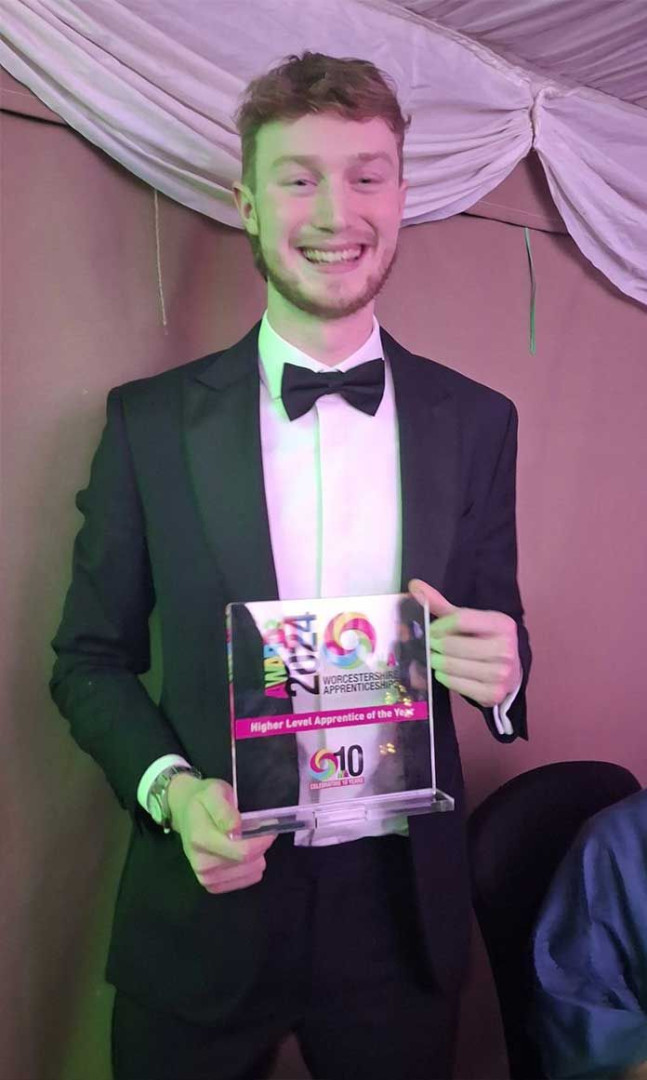 Josh, looking smart in black tie, smiling proudly as he holds his award